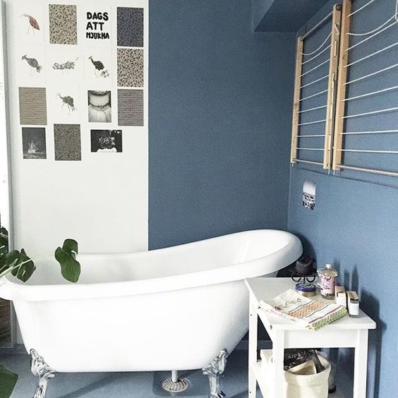 Love the moody blue paint and claw foot tub in this functional bathroom kellyelko.com