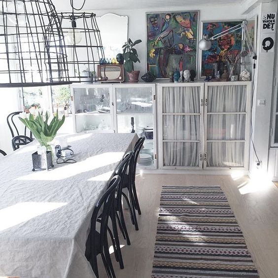 Love the oversized wire chandeliers and glass front cabinets in this minimalistic dining room kellyelko.com