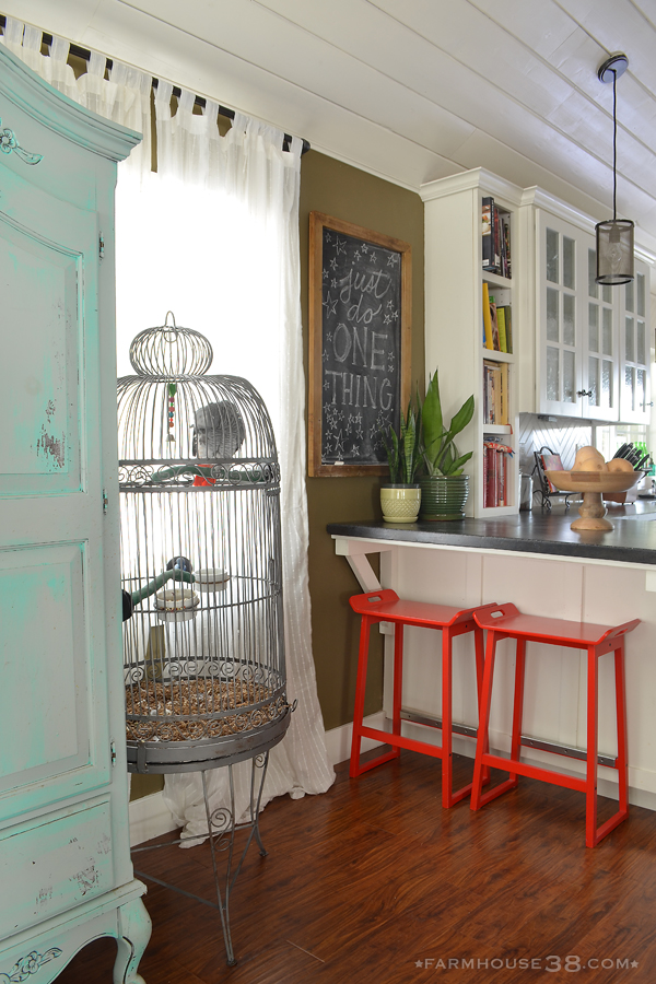 Eclectic and colorful home - love the giant bird cage and red bar stools kellyelko.com