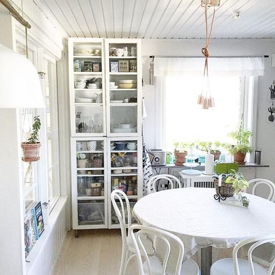 Love this simple kitchen with white bentwood chairs and glass front storage cabinet kellyelko.com