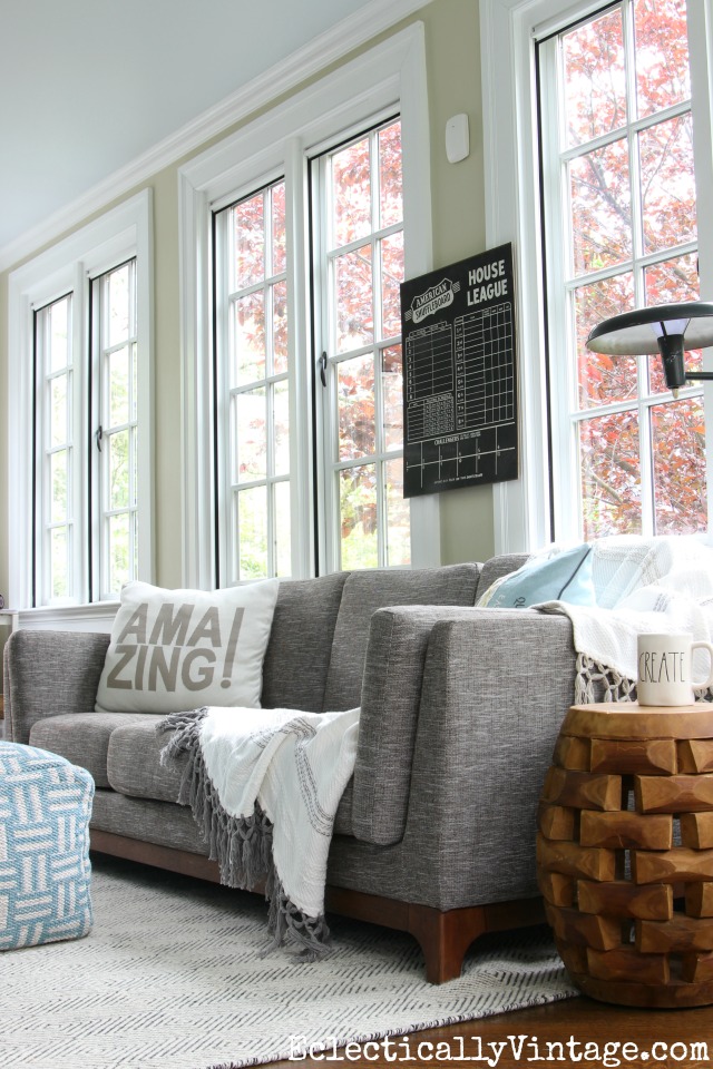 Love the huge windows in this beautiful sunroom with gray sofa and textured black and white rug kellyelko.com