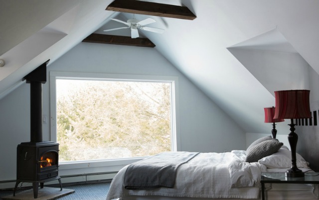 Love this cozy attic bedroom with exposed beams and wood burning stove kellyelko.com