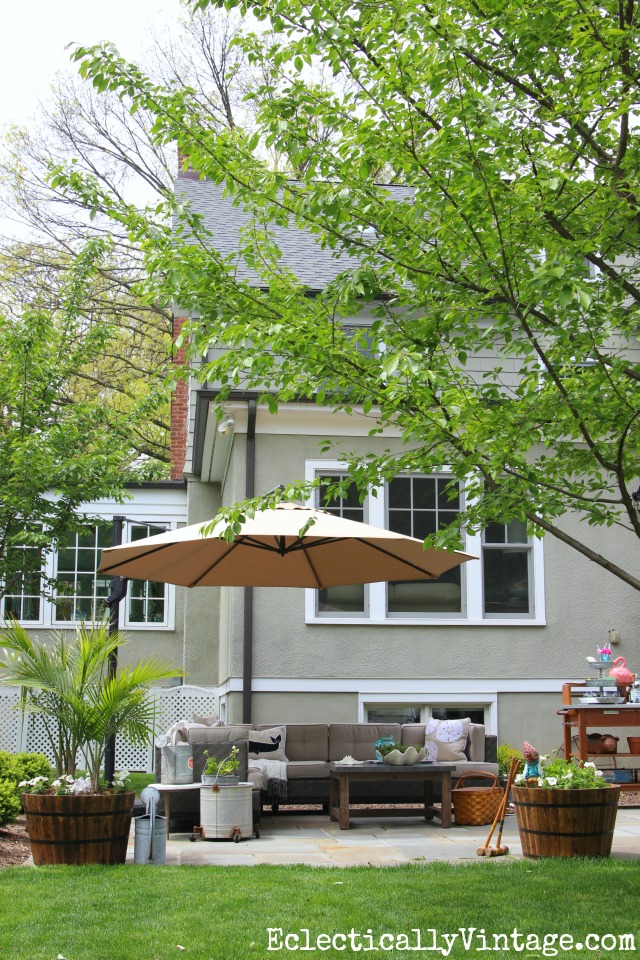 Backyard patio oasis - love the sectional sofa, plant stand turned bar cart and the giant cantilevered umbrella kellyelko.com
