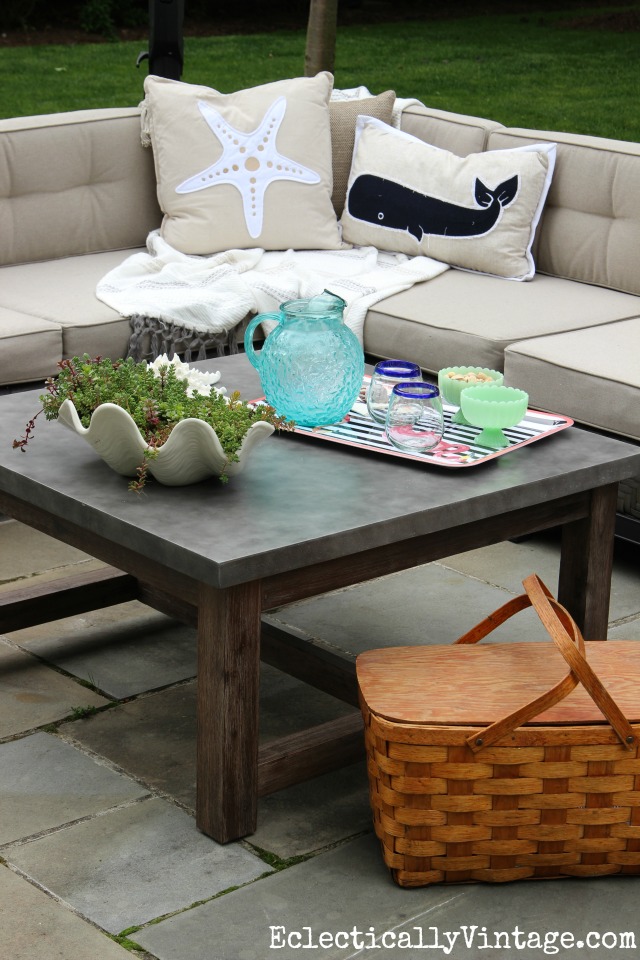 Love this huge concrete top outdoor coffee table and the sectional sofa with coastal pillows kellyelko.com