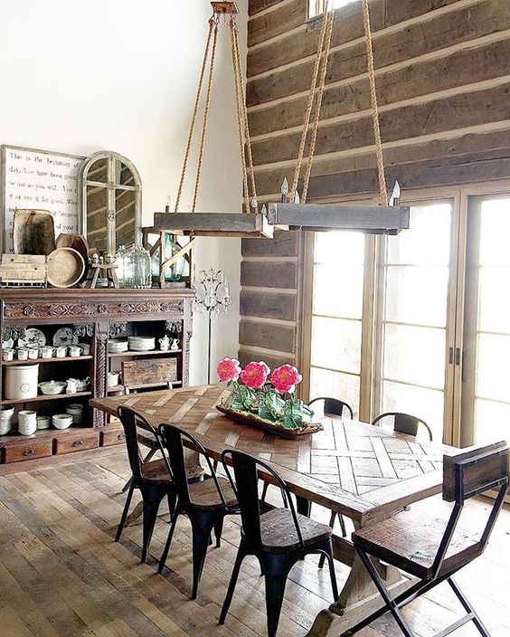 Love this rustic dining room - the rope chandeliers and farmhouse table paired with metal chairs are beautiful kellyelko.com