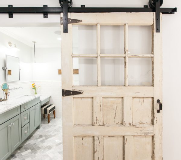 Love this chippy old sliding barn wood door in the bathroom kellyelko.com