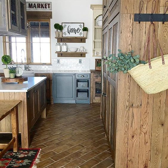 Love the rustic tile floor and blue lower cabinets in this farmhouse kitchen kellyelko.com