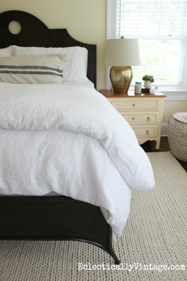 Serene neutral master bedroom with iron bed, neutral vintage linen duvet and bedding and hammered brass lamp kellyelko.com