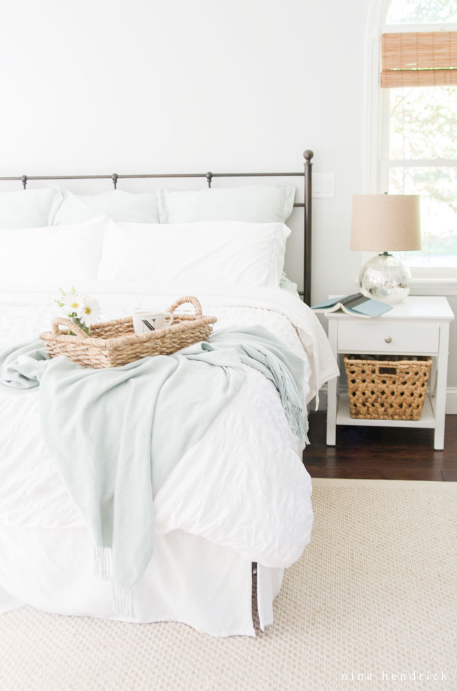 Cozy bedroom with iron bed and neutral bedding kellyelko.com