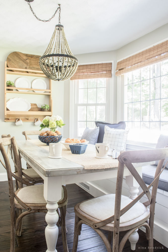 Love this farmhouse kitchen table with built in banquette mixed with x back chairs and beaded chandelier kellyelko.com