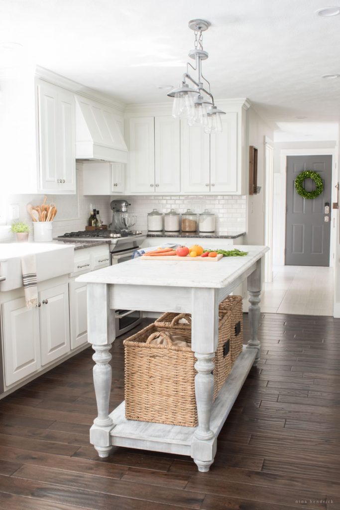 Farmhouse kitchen with painted white cabinets and DIY farmhouse island kellyelko.com