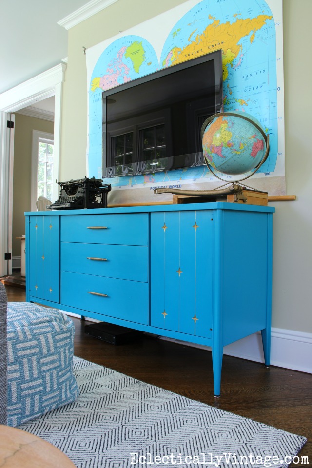 Love this blue painted mid century furniture - the perfect media cabinet and the vintage map is such a fun piece of wall art behind the tv kellyelko.com