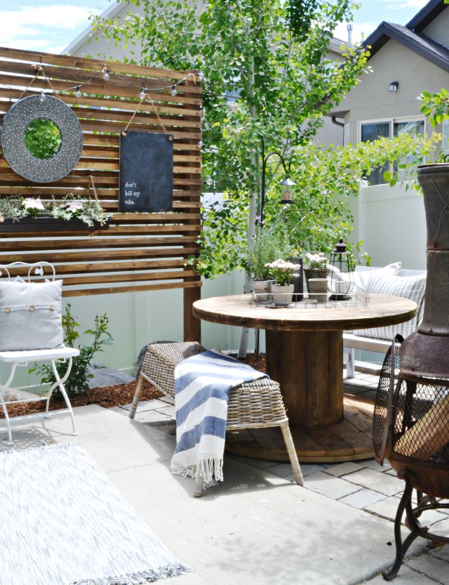 Love this patio with wood privacy screen and electric spool dining table kellyelko.com