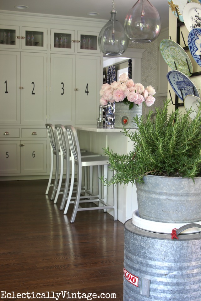 Love this white kitchen that gets personality from vintage finds like these galvanized vintage coolers used as vases! kellyelko.com