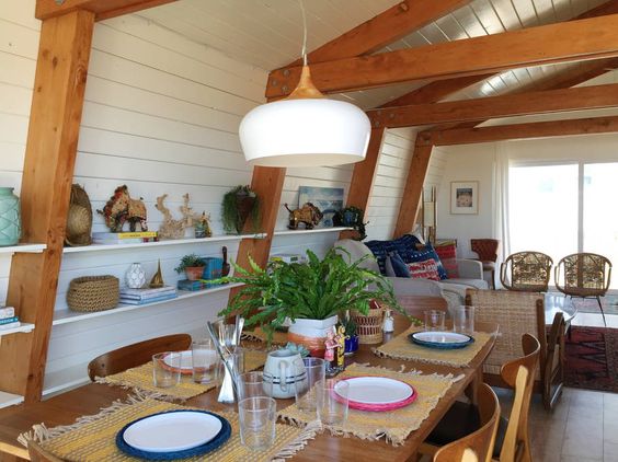 Beautiful dining room with shiplap walls and mid century furniture and lighting kellyelko.com