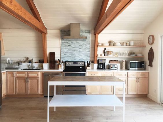 Modern kitchen with ceiling beams, shiplap walls and a huge stand alone island kellyelko.com