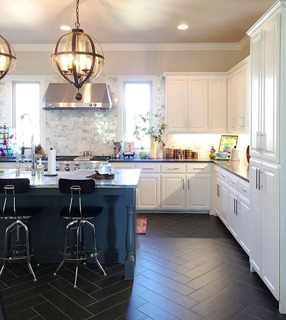 Love this white kitchen with black herringbone tile and the statement lighting! kellyelko.com