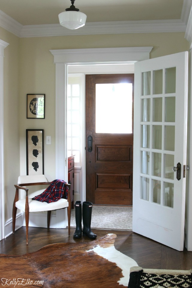 Love this neutral foyer with cowhide rug and schoolhouse light kellyelko.com